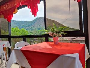 a red and white table with a view of a mountain at La Casa Milagrosa in Coron