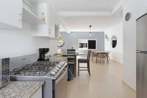 a kitchen with a stove and a table with chairs at Beach front Blue Summer Apartment Costa Del Sol in El Zapote