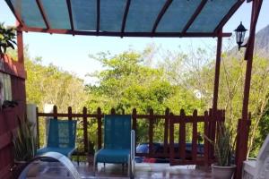 a patio with two chairs and a wooden fence at Comfort Suites - Special in Choiseul