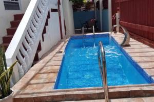 uma pequena piscina com água azul num quintal em Comfort Suites - Special em Choiseul