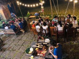 un gruppo di persone seduti a tavola con cibo di Goong House a Sa Pa