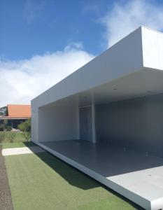 une vue extérieure sur un bâtiment blanc avec de l'herbe verte dans l'établissement Deluxe boutique lodge, à Vara Blanca