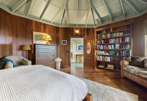 a bedroom with a bed and a book shelf at Kula Ohana in Captain Cook