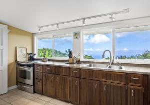 eine Küche mit einem Waschbecken und einem Fenster in der Unterkunft Kula Ohana in Captain Cook