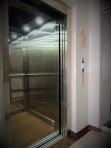 a glass elevator in a building with a no smoking sign at Hotel Cesar´s in Lima