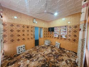 a room with wooden walls and a table and chairs at OYO Home Aalim Homestay 