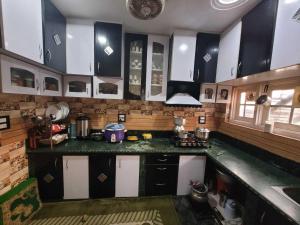 a kitchen with black and white cabinets and a counter top at OYO Home Aalim Homestay 