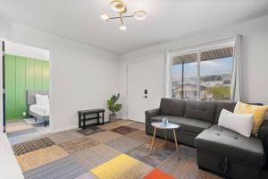 a living room with a couch and a table at Stylish Green & Gold 2BR / 1Bath Apartment in SFO in South San Francisco