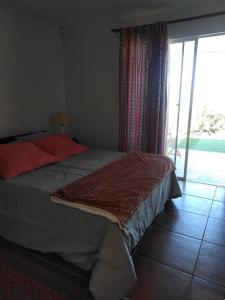 a bedroom with a bed and a sliding glass door at Casa Mamalluca in Vicuña