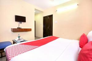 um quarto com uma cama e uma televisão na parede em Hotel Rajmahal em Jalandhar