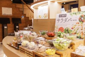 a buffet with bowls of food on a table at Ashibetsu Onsen Starlight Hotel in Ashibetsu