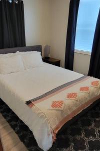 een slaapkamer met een bed met een zwart hoofdeinde en een raam bij Newly renovated home with WIFI and ROKU TV in Brimley