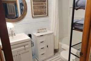een badkamer met een wastafel, een toilet en een spiegel bij Newly renovated home with WIFI and ROKU TV in Brimley