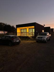 two cars parked in front of a house at COSTA LOBO ll in Pichilemu