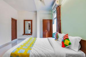 een slaapkamer met een groot bed met kleurrijke kussens bij OYO Dream Connect Stays Near City Center Mall in Hyderabad
