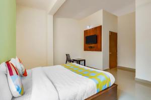 a bedroom with a bed and a tv on the wall at OYO Dream Connect Stays Near City Center Mall in Hyderabad