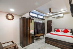 ein Schlafzimmer mit einem Bett mit roten Kissen in der Unterkunft OYO Shiva Guest House in Kamakhya