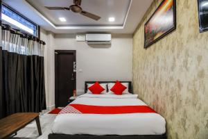 ein Schlafzimmer mit einem großen Bett mit roten Kissen in der Unterkunft OYO Shiva Guest House in Kamakhya