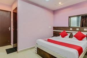 sypialnia z dużym łóżkiem z czerwonymi poduszkami w obiekcie Hotel Royal w mieście Rāj Nāndgaon
