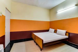 a small room with a bed in the corner at OYO Srinivasa Residency Lodge in Tirupati