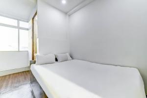 uma cama branca num quarto com uma janela em SPOT ON Plaza Guest House em Patna