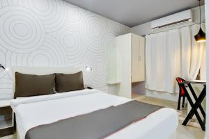 - une chambre avec un lit blanc et un mur dans l'établissement Collection O Airport View Guest House Airport Road, à Soalkuchi