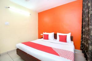 1 dormitorio con 1 cama con almohadas rojas y blancas en Hotel Rajmahal, en Jalandhar
