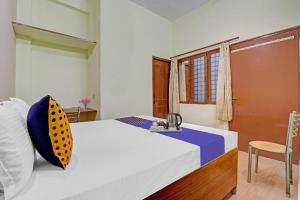 een slaapkamer met een bed, een wastafel en een raam bij SPOT ON Ganpati Home Stays in Dehradun