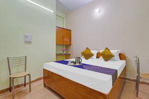 een slaapkamer met een bed met een wastafel en een stoel bij SPOT ON Ganpati Home Stays in Dehradun