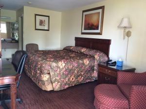 a hotel room with a bed and a chair at Knights Inn Augusta Fort Gordon in Augusta