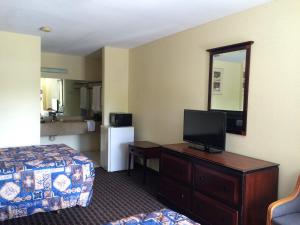 a hotel room with a bedroom with a bed and a television at Knights Inn Augusta Fort Gordon in Augusta