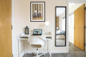 een wit bureau met een stoel en een spiegel bij Canal View Apartment - City Centre - Free Parking, Balcony, Fast Wifi, SmartTV with Netflix by Yoko Property in Northampton