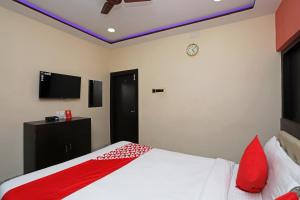 a bedroom with a bed and a tv on the wall at OYO Hotel Chinar in Dum Dum