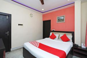 a bedroom with a bed with red walls at OYO Hotel Chinar in Dum Dum