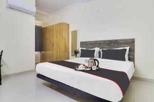 a bedroom with a large bed with a tray on it at Collection O Hotel Rio Kondapur Near Rahavendra Colony in Kondapur