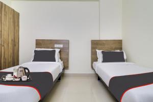 two beds in a hotel room with a tray of food at Collection O Hotel Rio Kondapur Near Rahavendra Colony in Kondapur