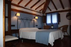 2 camas en una habitación con 2 sillas y una ventana en Hotel Mesón del Gallo, en Albarracín
