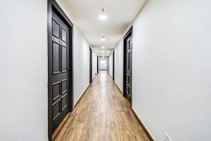 pusty korytarz z czarnymi drzwiami i drewnianą podłogą w obiekcie Townhouse The Royal Retreat w mieście Garui