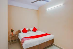 加濟阿巴德的住宿－Flagship The Siddhartha，一间卧室配有红色枕头的床