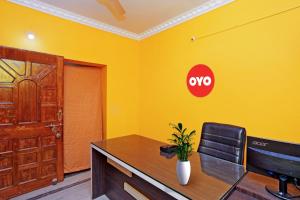 un ufficio con una scrivania e un cartello su una parete gialla di OYO Flagship Advik Cottage a Khandagiri