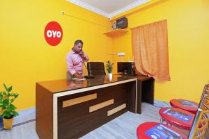 a man standing at a desk in an office at OYO Flagship Advik Cottage in Khandagiri