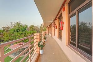 een balkon van een huis met potplanten bij Townhouse Jalsa Resort in Goshainganj
