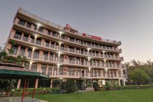 un grande edificio con un prato di fronte di Townhouse Jalsa Resort a Goshainganj