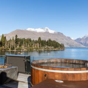 a hot tub on a deck with a view of a lake at Eichardt's Private Hotel in Queenstown