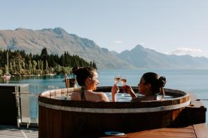 two women in a hot tub with glasses of wine at Eichardt's Private Hotel in Queenstown