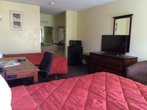 a hotel room with a bed and a desk and a tv at Knights Inn Augusta Fort Gordon in Augusta