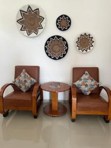 una stanza con due sedie e un tavolo e piatti appesi al muro di Pondok Serayu ad Ubud