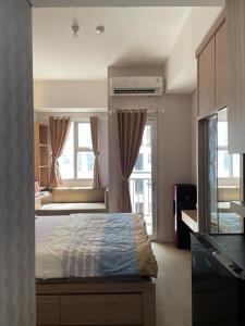 a bedroom with a bed and a large window at Apartemen Studio View Waterpark in Bulanbulan