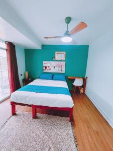 a bedroom with a bed with a green wall at The Bleu Mansion Iligan in Iligan City