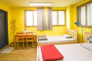 um quarto com duas camas e uma mesa e uma sala de jantar em Daegu Midtown Hostel em Daegu